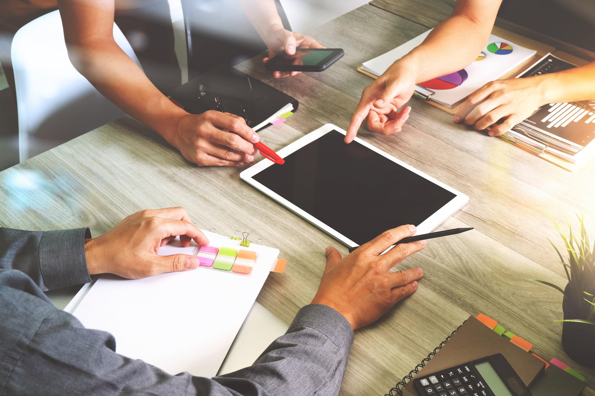 Team am Arbeitstisch mit Tablet